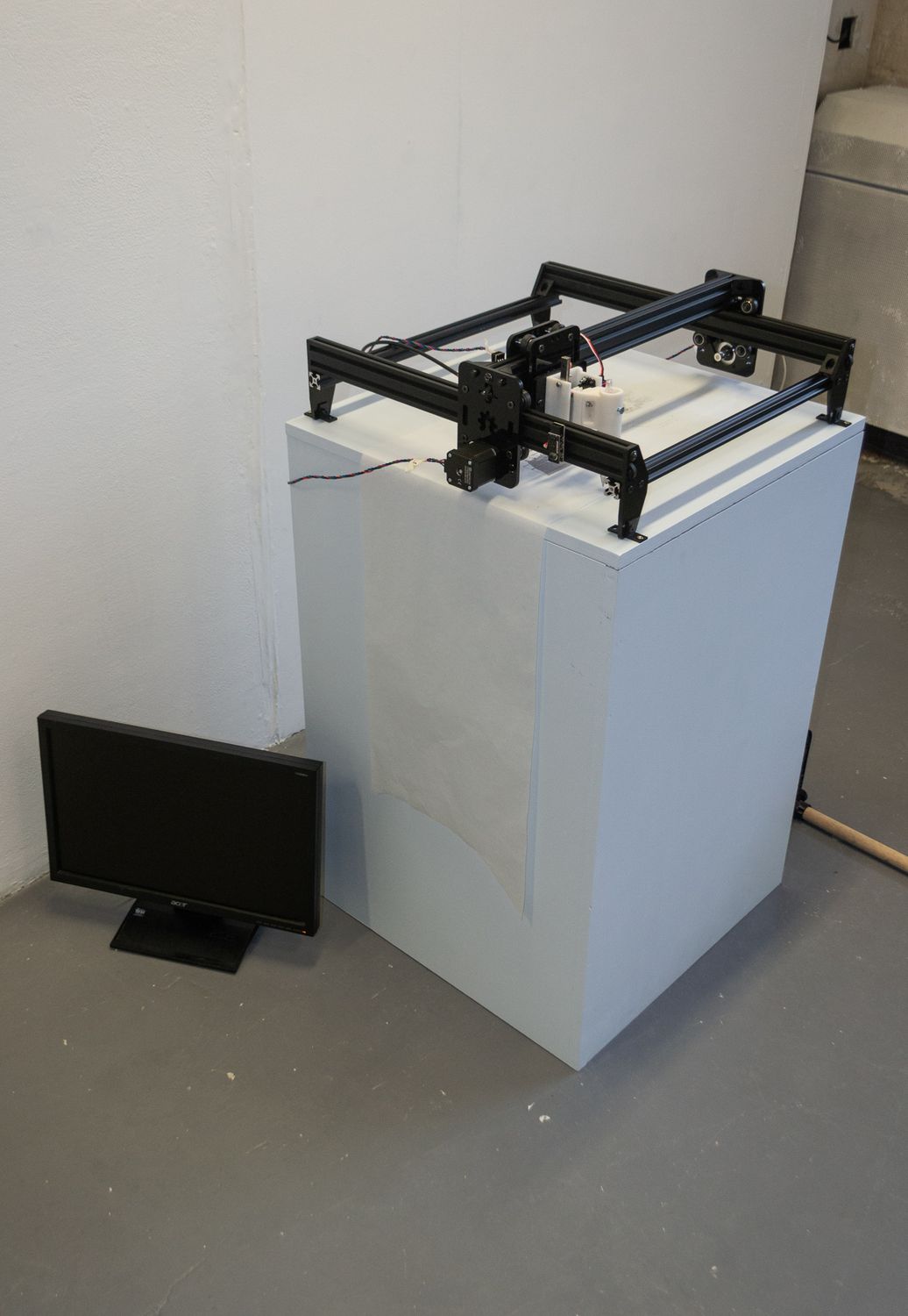 The plotter installation, featuring the screen that displayed the meme currently being drawn at that moment. An image of the plotter from Repost; Remake.